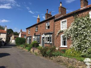 a brick house with white windows on a street at Cosy Lincs Wolds cottage in picturesque Tealby in Tealby