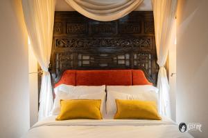a bed with an orange headboard and two yellow pillows at Suite Opium Den by Justine Apartments Apartamento turístico en Madrid Río in Madrid