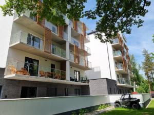 un edificio de apartamentos con un coche aparcado delante de él en LAGUNA Apartament Polanica Residence 2, en Polanica-Zdrój