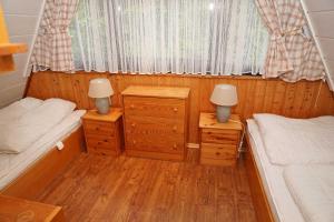 Dormitorio pequeño con 2 camas y 2 lámparas en Zeltdachhaus mit W LAN sehr strand, en Damp