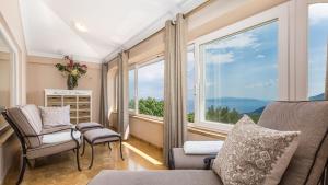 a living room with a couch and chairs and a large window at Apartments Villa BV in Opatija