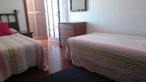 a bedroom with two beds and a dresser with a mirror at Siestamar in Cala en Porter