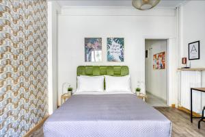 een slaapkamer met een groot bed met een groen hoofdeinde bij Studio in The Heart of Acropolis in Athene