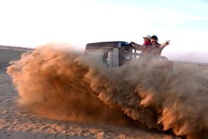 Zwei Leute reiten in einem Jeep in der Wüste in der Unterkunft Exotic Luxury Camps in Jaisalmer