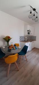 a dining room with a table and chairs and a kitchen at Riva Lodge in Saint-Aignan