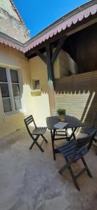 a picnic table and two chairs on a patio at Riva Lodge in Saint-Aignan