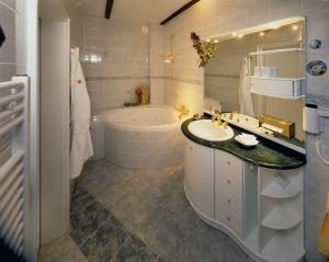 a bathroom with a tub and a sink and a bath tub at Gasthaus Stobbermühle in Buckow