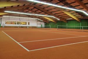 a tennis court in a building with a tennis court at Matchpoint Hotel in Altdorf bei Nuernberg