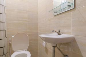 a bathroom with a toilet and a sink at NYENYAK MRT Lebak Bulus Simatupang in Jakarta