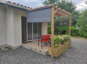 a red chair sitting on a wooden deck with a gazebo at appartement Anna in Parentis-en-Born
