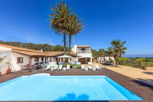 a villa with a swimming pool and palm trees at Es Pas Formentera Agroturismo in Es Calo