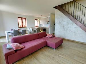 a living room with a red couch and a kitchen at Apartment -2 by Interhome in Gera Lario