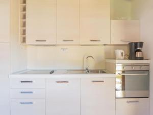 een keuken met witte kasten en een spoelbak bij Apartment Giuse - DMA206 by Interhome in Domaso