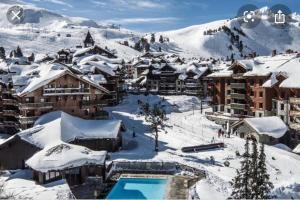 a resort in the snow with a pool at ARC 1950 - Hameau du Glacier appartement duplex 8 pers in Arc 1950