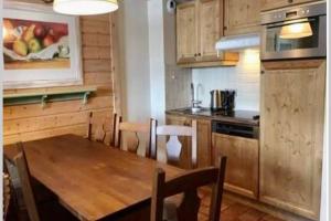 a kitchen with a wooden table in a kitchen at ARC 1950 - Hameau du Glacier appartement duplex 8 pers in Arc 1950