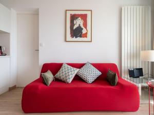 ein rotes Sofa mit Kissen darauf im Wohnzimmer in der Unterkunft Apartment Ur Gaina-3 by Interhome in Bidart