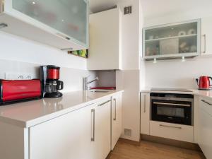 a white kitchen with white cabinets and a red appliance at Apartment Ur Gaina-3 by Interhome in Bidart