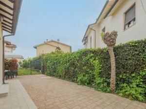 uma cerca com uma árvore ao lado de um edifício em Holiday Home Manuela by Interhome em Marina di Pietrasanta