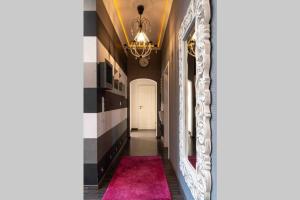 ein Flur mit einem Spiegel und einem rosa Teppich in der Unterkunft Altes Kappellchen im alten Schwesternhaus in Weibern