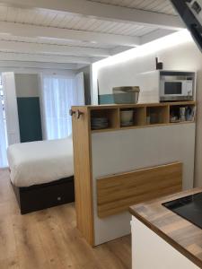 Dormitorio pequeño con cama y microondas en Apartamento completamente equipado en Pontedeume., en Puentedeume