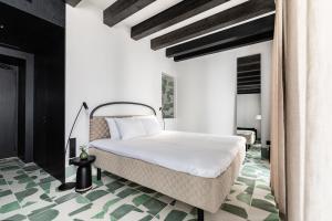 1 dormitorio con 1 cama blanca y suelo verde en Concepcio by Nobis, Palma, a Member of Design Hotels en Palma de Mallorca