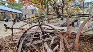 an old wooden cart sitting on the ground at BAROSSA HILLS COTTAGES in Springton