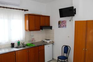 eine kleine Küche mit Holzschränken und einem Waschbecken in der Unterkunft VILLA BORA in Leptokaryá