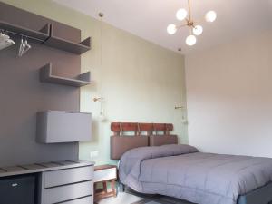 ナポリにあるEuforia Napoli - Tre Sedi - Three Locationsのベッドルーム1室(ベッド2台、薄型テレビ付)