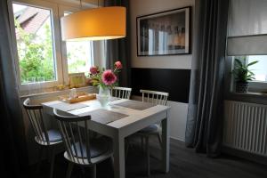 a dining room table with chairs and a vase of flowers at Ferienwohnung Blumengarten in Marburg an der Lahn