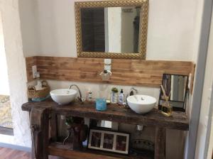 uma casa de banho com 2 lavatórios numa mesa de madeira em Atelier de peinture au Moulin de Gâteau - Atelier sur l'eau em La Vallée