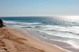 a group of people on a beach near the ocean at Villa Flavia in Aljezur