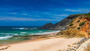 a beach next to the ocean with a cliff at Villa Flavia in Aljezur