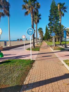 a sidewalk with street signs in front of the beach at Apartamento la romanilla a 200metros de la playa in Roquetas de Mar