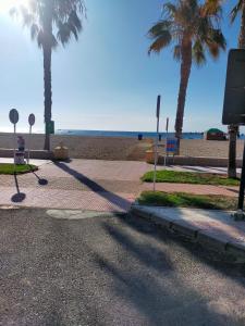 a sidewalk next to the beach with palm trees at Apartamento la romanilla a 200metros de la playa in Roquetas de Mar