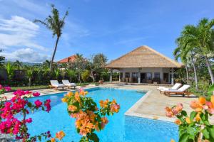 Una villa con piscina y un complejo turístico. en Villa Duyung, en Buleleng