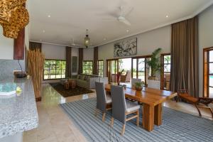Un comedor y una sala de estar con mesa y sillas. en Villa Duyung, en Buleleng