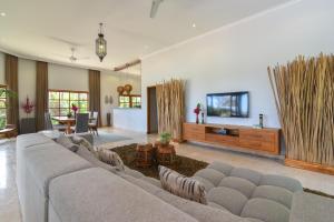 sala de estar con sofá grande y TV en Villa Duyung, en Buleleng
