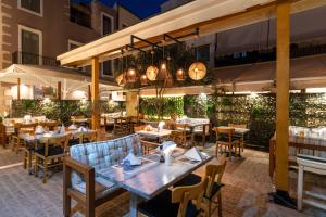 a restaurant with tables, chairs, tables and umbrellas at Palazzino Di Corina in Rethymno