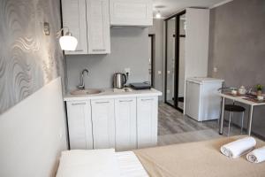 a kitchen with a bed and a sink in a room at Guest house On Griboedova Street in Sochi