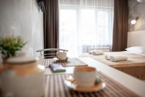 una habitación de hotel con 2 camas y una taza de café sobre una mesa en Guest house On Griboedova Street, en Sochi