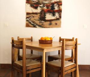 uma mesa de madeira com cadeiras e uma taça de fruta em The Wild Olive Andalucía Citrus Suite em Casares