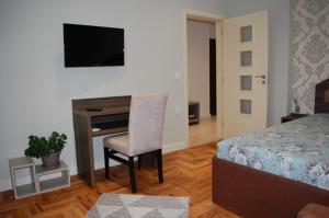 1 dormitorio con escritorio y 1 cama con silla en Апартамент Здравец, en Tryavna