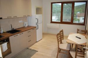 eine Küche mit einem Tisch und einem weißen Kühlschrank in der Unterkunft Апартамент Здравец in Trjawna