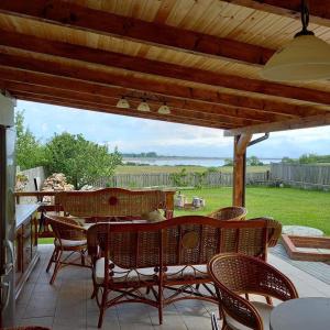 a patio with a table and chairs under a wooden roof at Casuta-Lacului in Unciuc