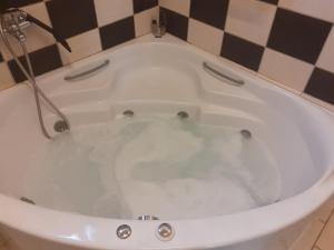 e bagno con vasca riempita d'acqua. di White Manolia Cottage a Kato Korakiana