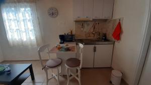 una piccola cucina con un piccolo tavolo e sedie di White Manolia Cottage a Kato Korakiana Altre 12 foto