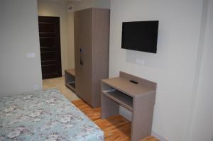 ein Schlafzimmer mit einem Bett und einem TV an der Wand in der Unterkunft Апартамент Здравец in Trjawna