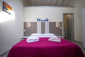 帕爾馬的住宿－Le PALME，一间卧室配有粉红色的床和2条毛巾