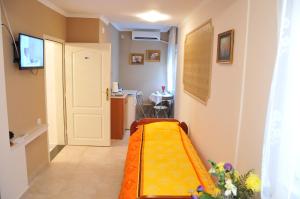 Zimmer mit einem Bett mit einer orangefarbenen Decke in der Unterkunft Royal Apartments in Niš
