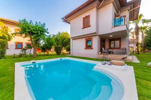 a swimming pool in front of a house at Vista Villas in Belek